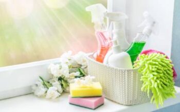 a basket of cleaning supplies on a windowsil